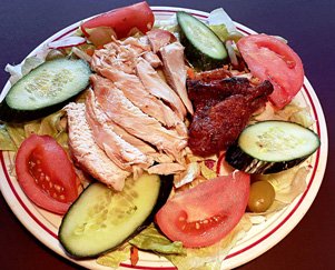 poitrine de poulet tranchée sur une assiette de salade de jardin fraîche